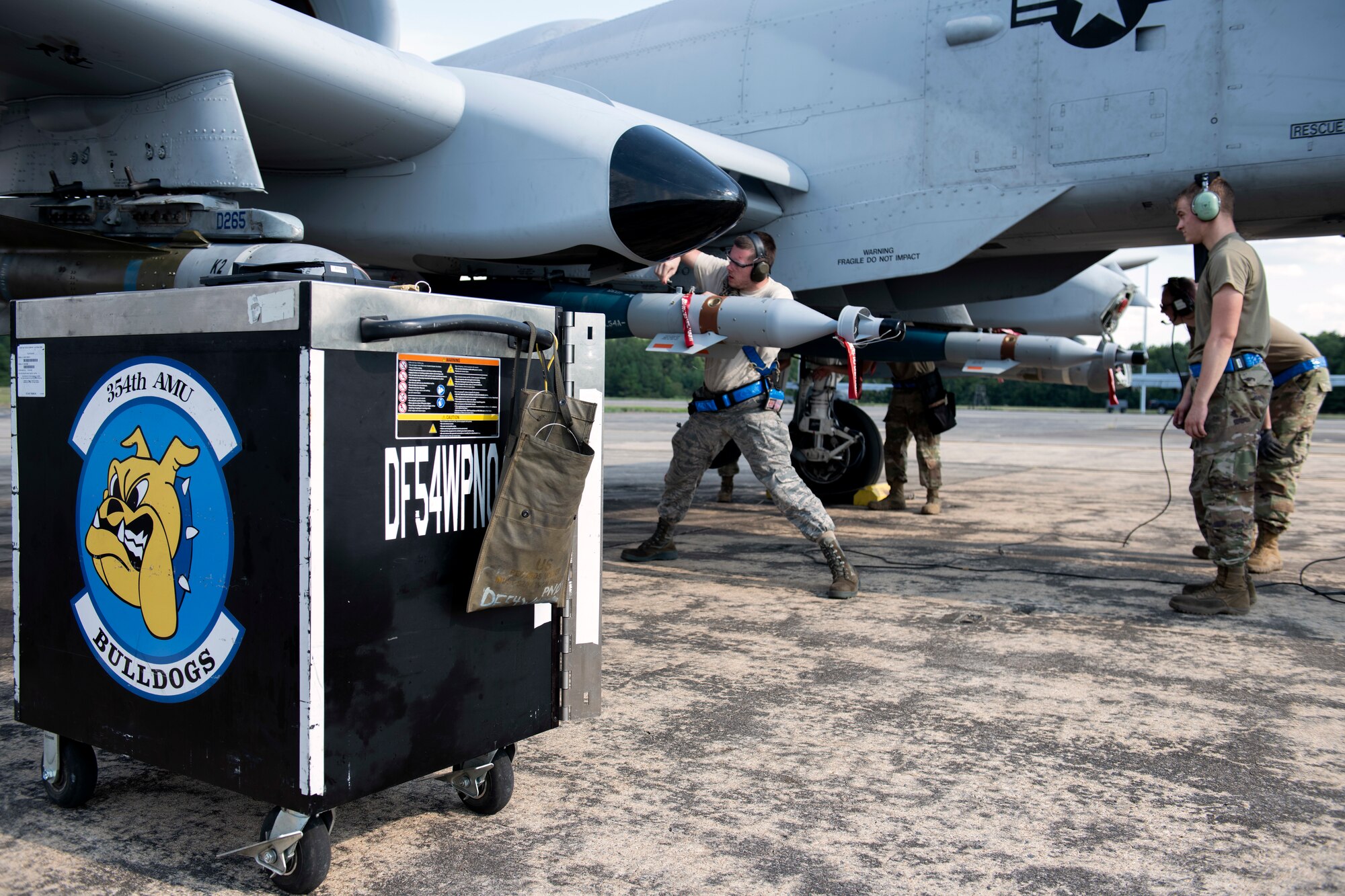 Airmen load an inert munition onto an aircraft