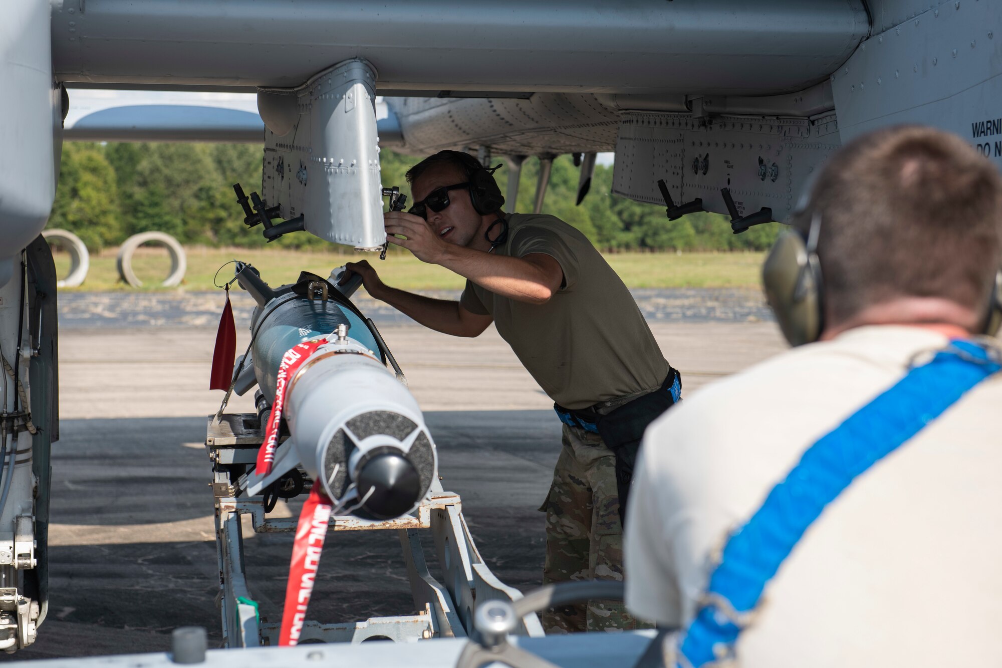 Airmen load an inert weapon onto an aircraft