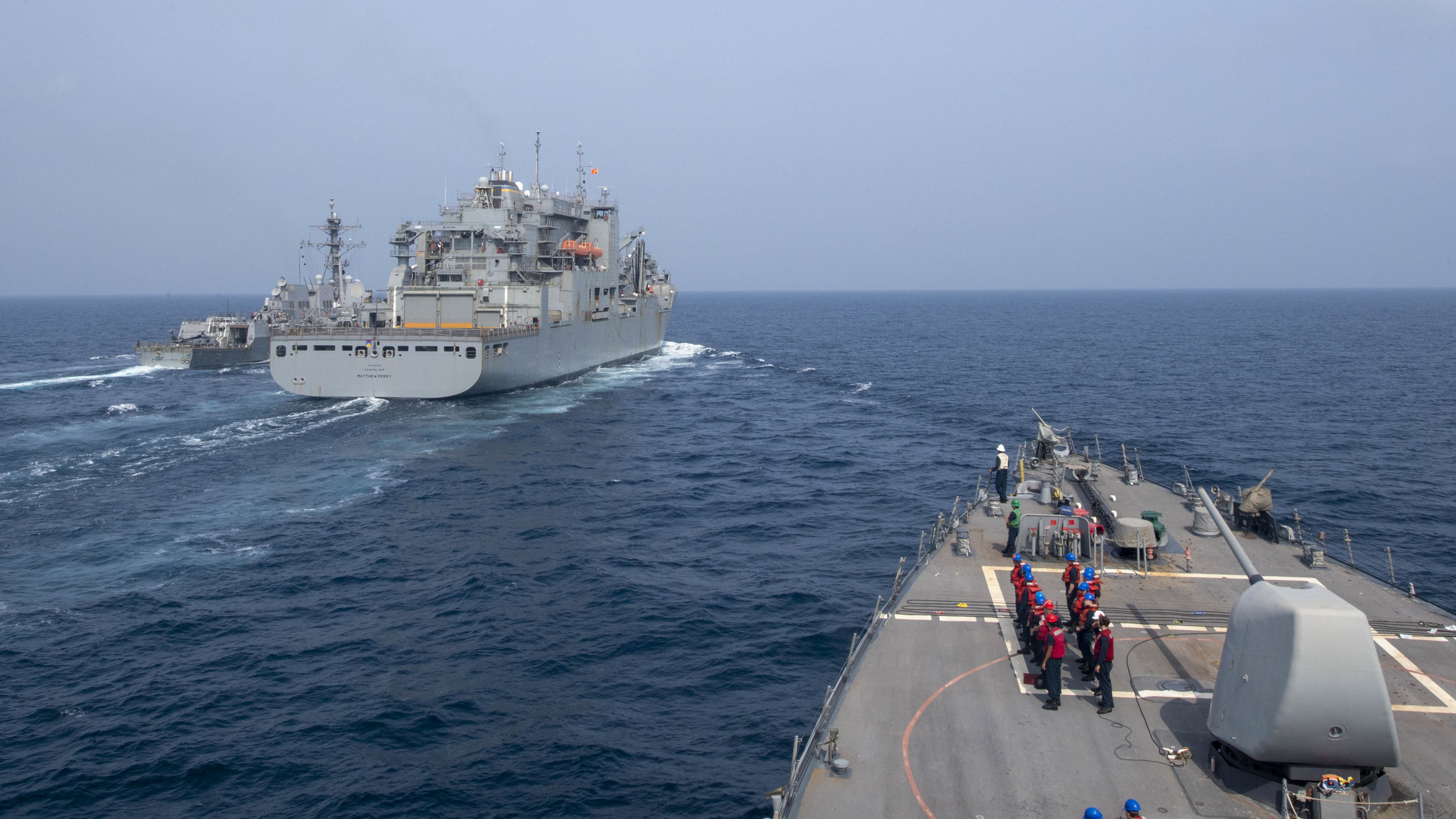 The guided-missile destroyer USS Paul Hamilton (DDG 60) approaches the Military Sealift Command dry cargo and ammunition ship USNS Matthew Perry (T-AKE-9), while conducting a replenishment-at-sea with the guided-missile destroyer USS Ralph Johnson (DDG 114).