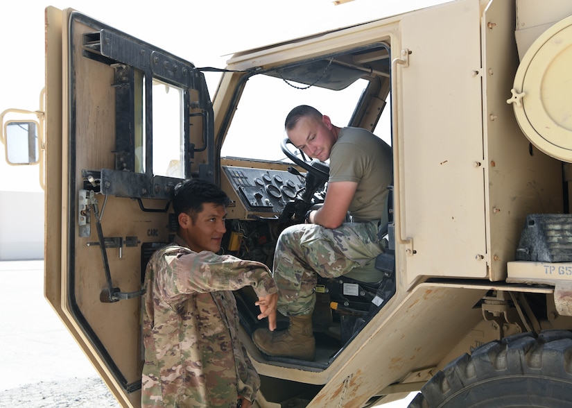 Army Specialist Jose Arellano (left), instructor for the 133rd Battalion, gives instructions to lift the pallet of the M1075 Palletized Load System, as Air Force Senior Airman Aiden Penrod, 380th Expeditionary Logistics Readiness Squadron ground transportation apprentice, looks on, July 22, 2020, at Al Dhafra Air Base, United Arab Emirates.