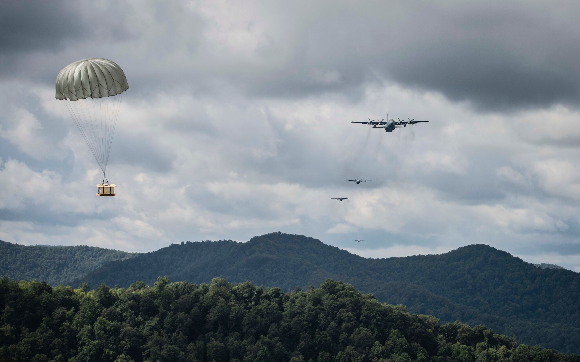 Cargo parachutes toward the drop zone as multiple C-130 aircraft perform an airdrop near Charleston, W. Va., Aug. 24, 2020. Eight C-130s from Reserve and Guard partners participate in a week-long training event. The scenario was designed to test the abilities of Air Force Reserve units to execute rapid global mobility missions in challenging, contested scenarios. (U.S. Air Force Reserve photo by Senior Airman Nathan Byrnes)