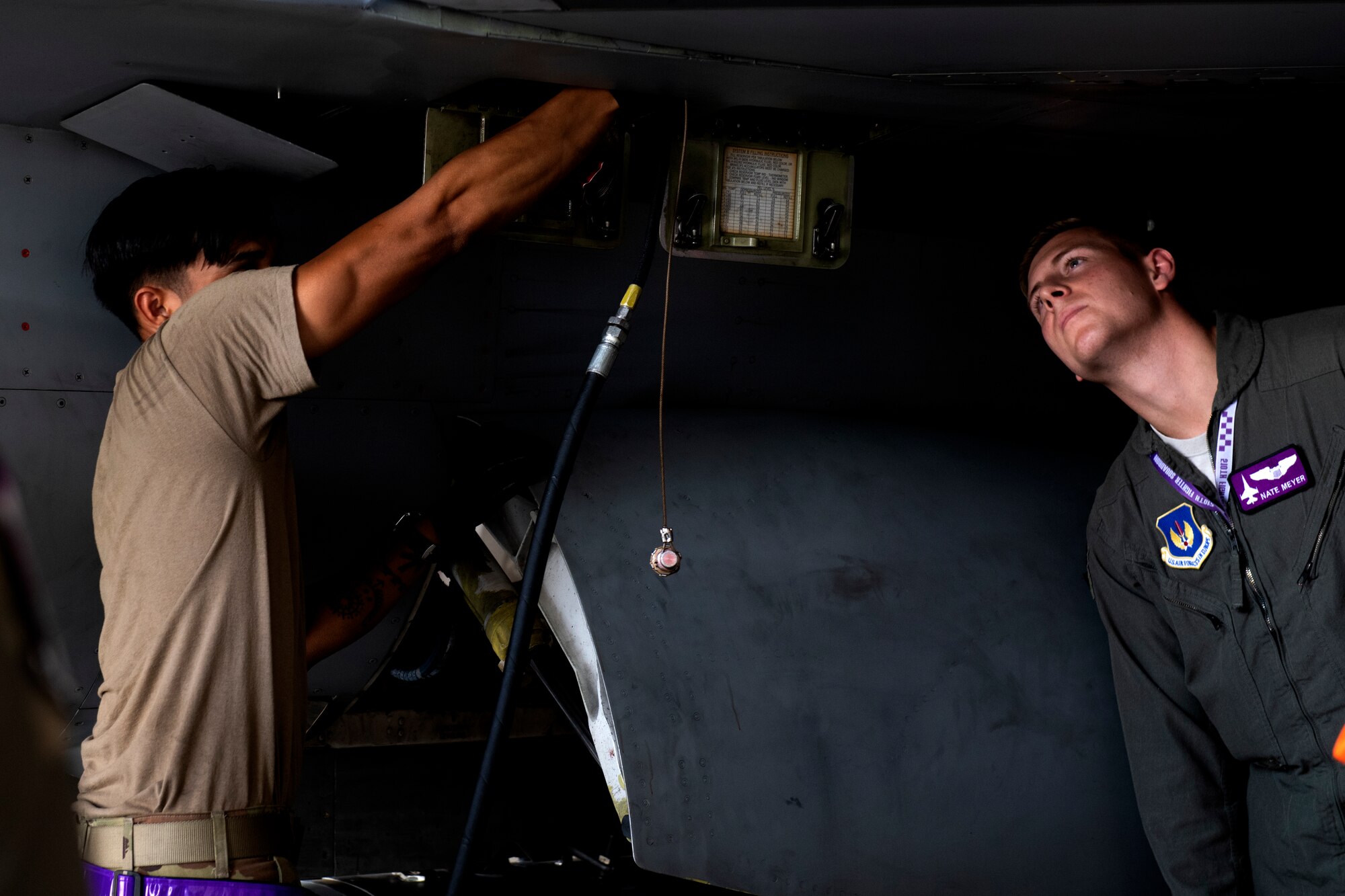 U.S. Air Force Staff Sgt. Marco Elbo, 510th Aircraft Maintenance Unit dedicated crew chief, demonstrates F-16 Fighting Falcon maintenance steps to U.S. Air Force 1st Lt. Nathan Meyer,  510th Fighter Squadron pilot, at Aviano Air Base, Italy, Aug. 13, 2020. The 510th FS and 510th Aircraft Maintenance Unit joined together for a Buzzard Unity event to bolster their working relationship. (U.S. Air Force photo by Senior Airman Caleb House)