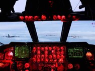 B-52s are seen flying in formation out of the window of a cockpit window