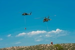 The Colorado National Guard is helping fight wildfires in the state in August 2020 with a CH-47 Chinook helicopter and two UH-60 Black Hawk helicopters, like these shown with aerial water buckets July 3, 2018, at Buckley Air Force Base, Aurora, Colorado.