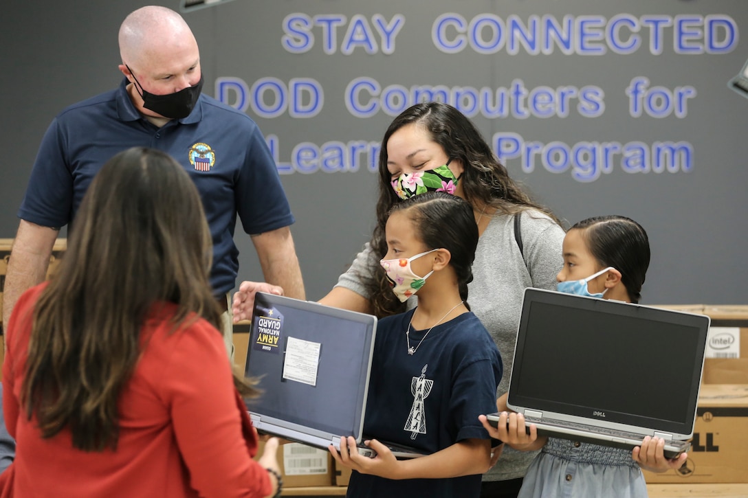 Students in Guam investigate new laptop computers.