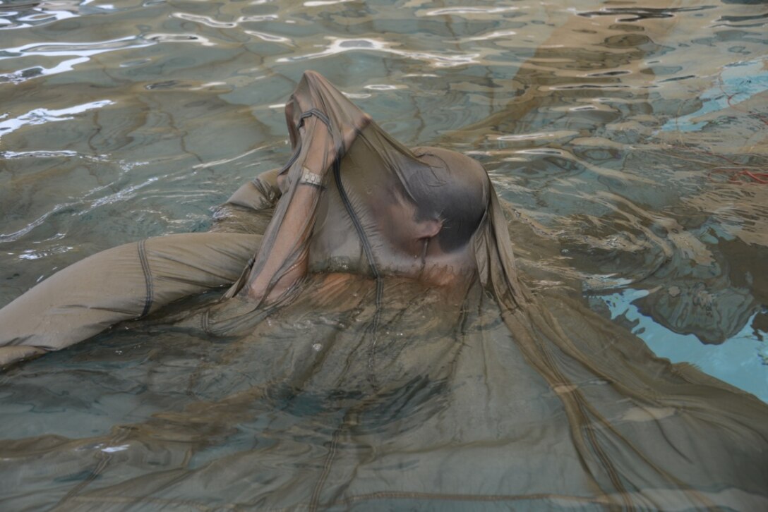 image of a A Special Tactics operator creating an air pocket of a drenched parachute during wet silk training,