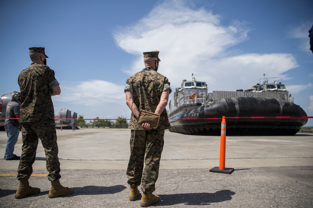 Assistant Commandant of the Marine Corps Gen. Gary L. Thomas (left) and Lt. Gen. Eric Smith, deputy commandant of Comabt Development and Integration watch a Landing Craft Air Cushion come ashore during a tour of the Textron Marine and Land Systems Shipyard in New Orleans, Aug. 11, 2020. Thomas toured the shipyards to assess capabilities and production of multiple Navy and Marine Corps projects during the novel Coronavirus pandemic. (U.S. Marine Corps photo by Sgt. Wesley Timm)