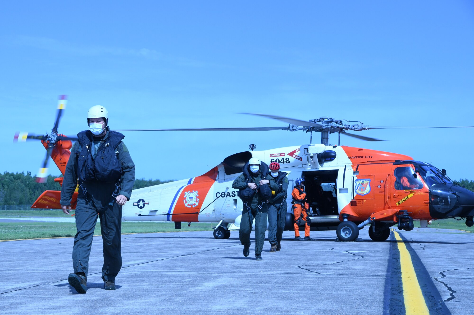 Pilots and aircrew flight equipment personnel from the 148th Fighter Wing, Minnesota Air National Guard exit a U.S. Coast Guard MH-60 Jayhawk from Air Station Traverse City, Michigan after being hoisted from Lake Superior during a joint water survival and rescue training mission near Duluth, Minnesota on August 25, 2020.