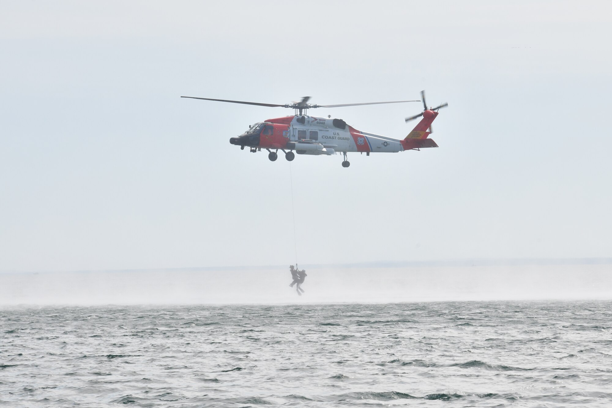 A U.S. Coast Guard MH-60 Jayhawk from Air Station Traverse City, Michigan hoists an F-16 pilot from the 148th Fighter Wing, Minnesota Air National Guard from Lake Superior, near Duluth, Minnesota during a water survival and rescue training mission.