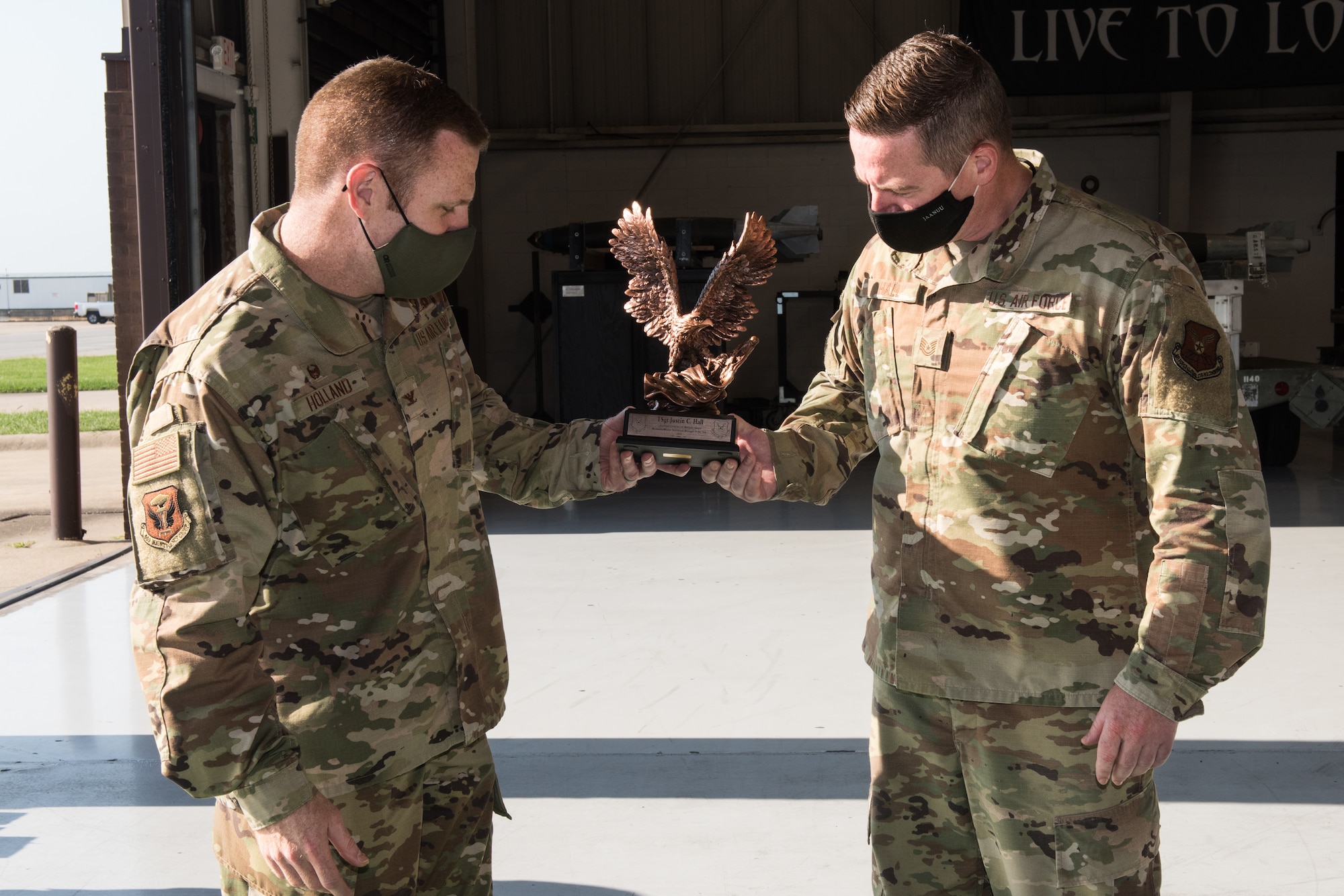 U.S. Air Force Jeffrey Col. Holland, 509th Maintenance Group commander, left, presents the Lt. Gen. Leo Marquez Award to Tech. Sgt. Justin Hall, 509th MXG loading standardization crew member, right, at Whiteman Air Force Base, Missouri, Aug. 14, 2020. Hall won the award of Technician Supervisor Category NCO Munitions/Missile Maintenance. This award recognizes military and civil service aircraft, munitions, and missile maintenance personnel who perform hands-on maintenance or manage a maintenance function. (U.S. Air Force photo by Airman 1st Class Christina Carter)