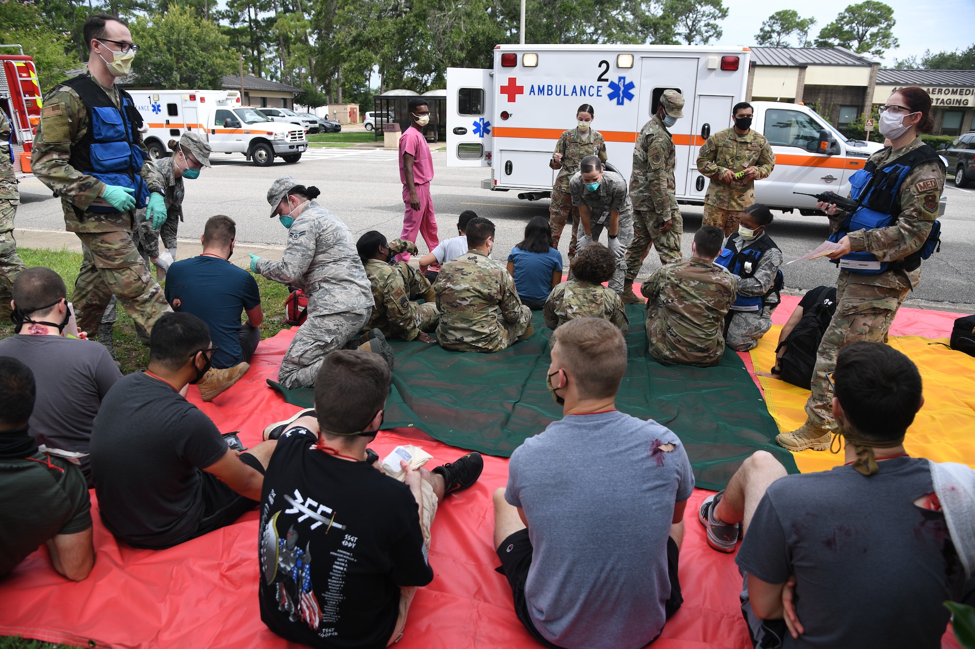 Keesler first responders medically assess actors portraying victims during an active shooter exercise outside the Sablich Center at Keesler Air Force Base, Mississippi, Aug. 20, 2020. The scenario included two active duty Air Force members who simulated opening fire inside the Sablich Center in order to test the base's ability to respond to and recover from a mass casualty event. (U.S. Air Force photo by Kemberly Groue)