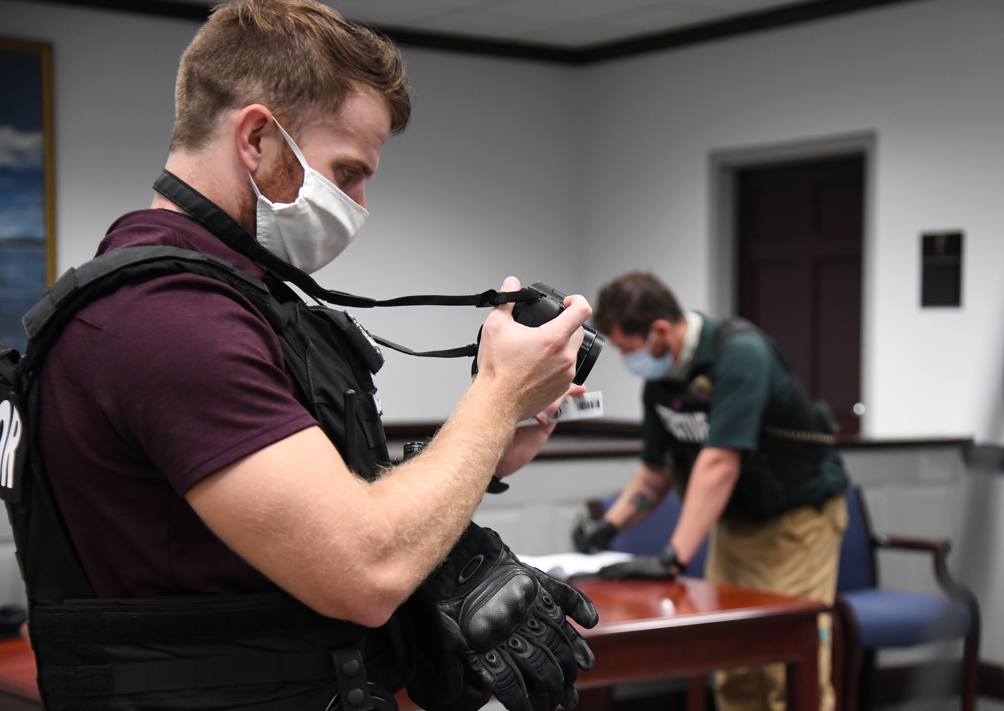 U.S. Air Force Staff Sgt. Ryan Ingrassia, 81st Security Forces Squadron investigator, and Chris Soukup, 81st SFS detective, document the crime scene for evidence inside the Sablich Center during an active shooter exercise at Keesler Air Force Base, Mississippi, Aug. 20, 2020. The scenario included two active duty Air Force members who simulated opening fire inside the Sablich Center in order to test the base's ability to respond to and recover from a mass casualty event. (U.S. Air Force photo by Kemberly Groue)