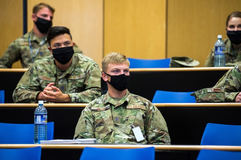 Masked students sit in a classroom.