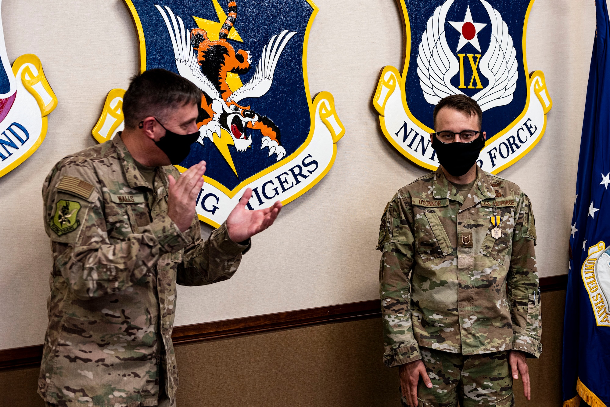 Photo of Airman getting congratulated by commander.