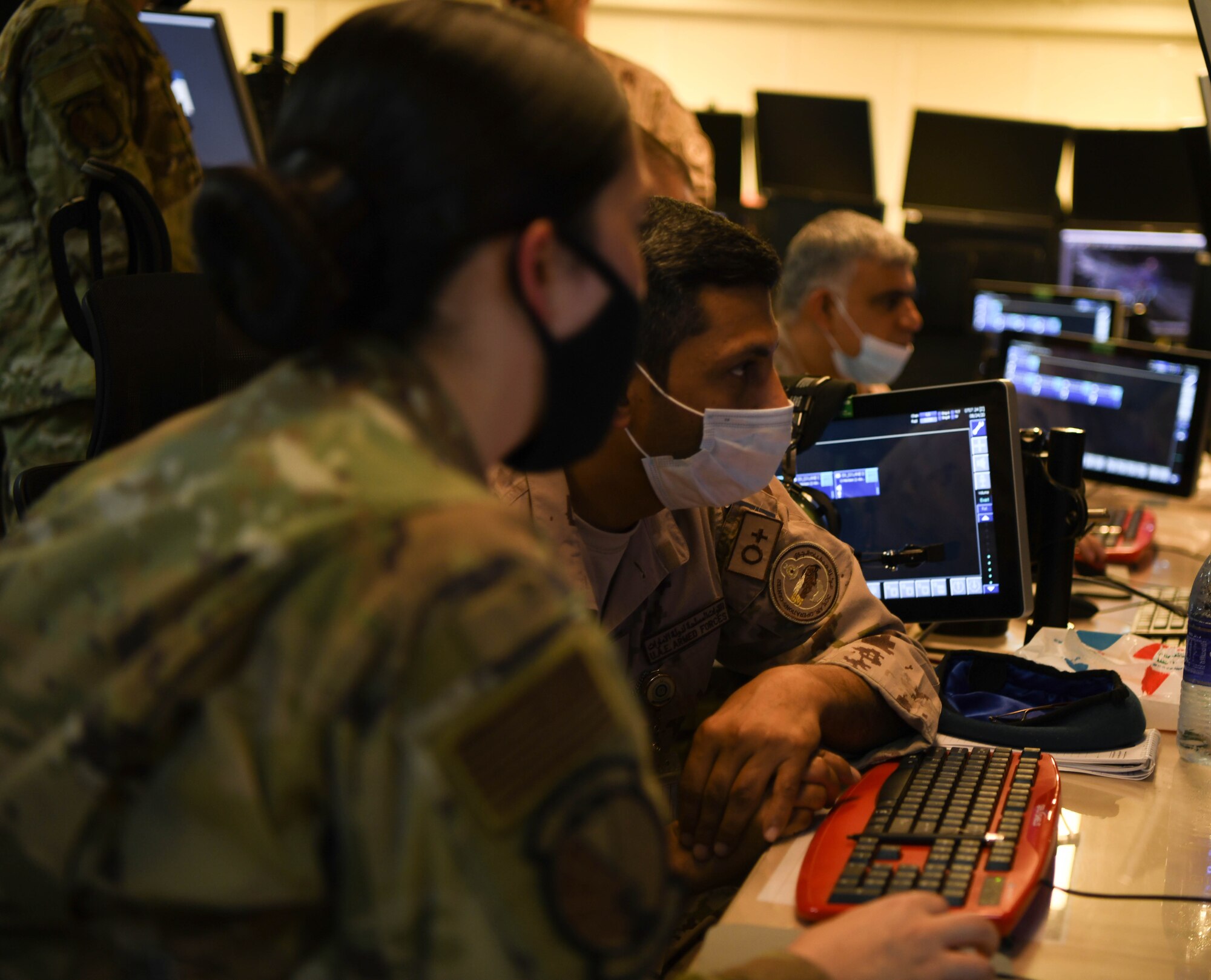 Lt. Col. Sulayman Al-Naqbi (center), a United Arab Emirates Air Operations Center weapons director, along with Col. Abdallah Ali Mohamed Al-Bloushi, U.A.E. AOC deputy commander, look into computer monitors during a visit to the 727th Expeditionary Air Control Squadron headquarters (Kingpin), August 24, 2020, in Al Dhafra Air Base, United Arab Emirates.