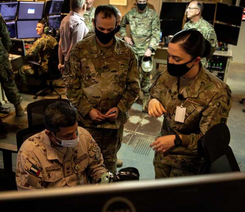 Lt. Col. Sulayman Al-Naqbi, United Arab Emirates Air Operations Center weapons director, discuss operations with Capt. Morgan Huttes, 727th Expeditionary Air Control Squadron headquarters section lead, and Senior Airman Mariah Byrum, 727 EACS weapons director, during a visit to 727 EACS headquarters (Kingpin), August 24, 2020, at Al Dhafra Air Base, United Arab Emirates.