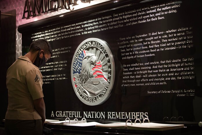 A U.S. Marine looks through a book of photography at America’s Heroes Memorial during a professional development event in the Pentagon at Washington, D.C. on Aug. 13.