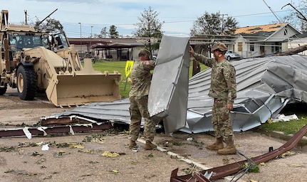 As the sun rises over Southwest Louisiana Aug. 27, 2020, members of the Louisiana National Guard clear roadways in Lake Charles and begin to assess the damage from Hurricane Laura.