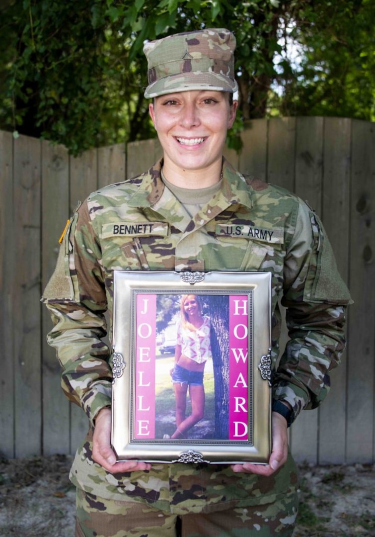 Pvt. Ana-Alicia Bennett poses with a photograph of her sister, Joelle, who died in a car accident just before her 20th birthday.
