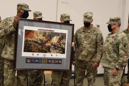 Col. Joseph A. DiNonno receives a framed print from the leaders of the 116th Infantry Brigade Combat Team.