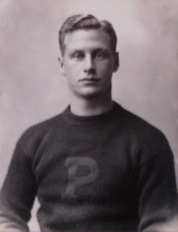 A man in a Princeton letter sweater poses for a photo.