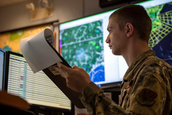 Weather journeyman, Senior Airman Schmuel Rottman from the 4th Operations Support Squadron weather flight  reviews the weather before briefing an F-15E Strike Eagle pilot at Seymour Johnson Air Force Base, North Carolina, June 10, 2020.