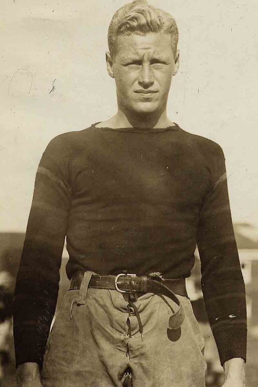 A man in a football uniform poses for a photo.