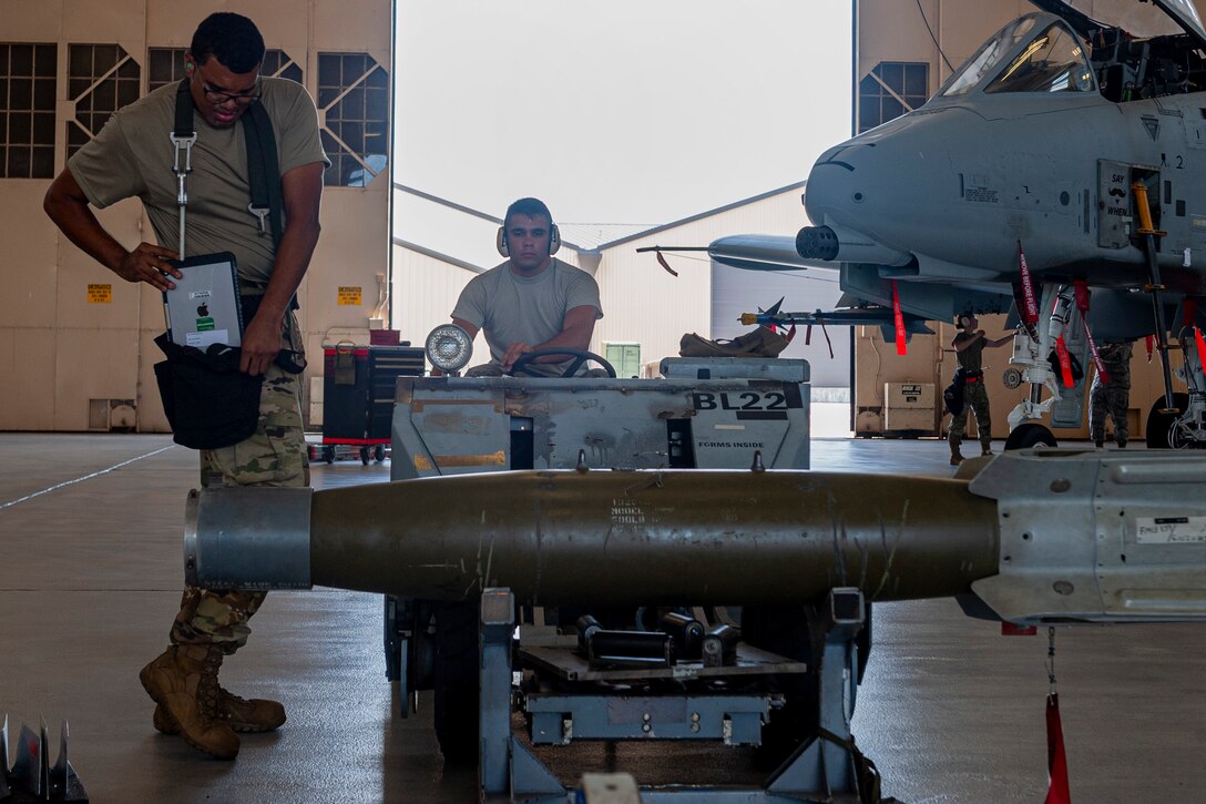 Photo of an Airman transporting a munition