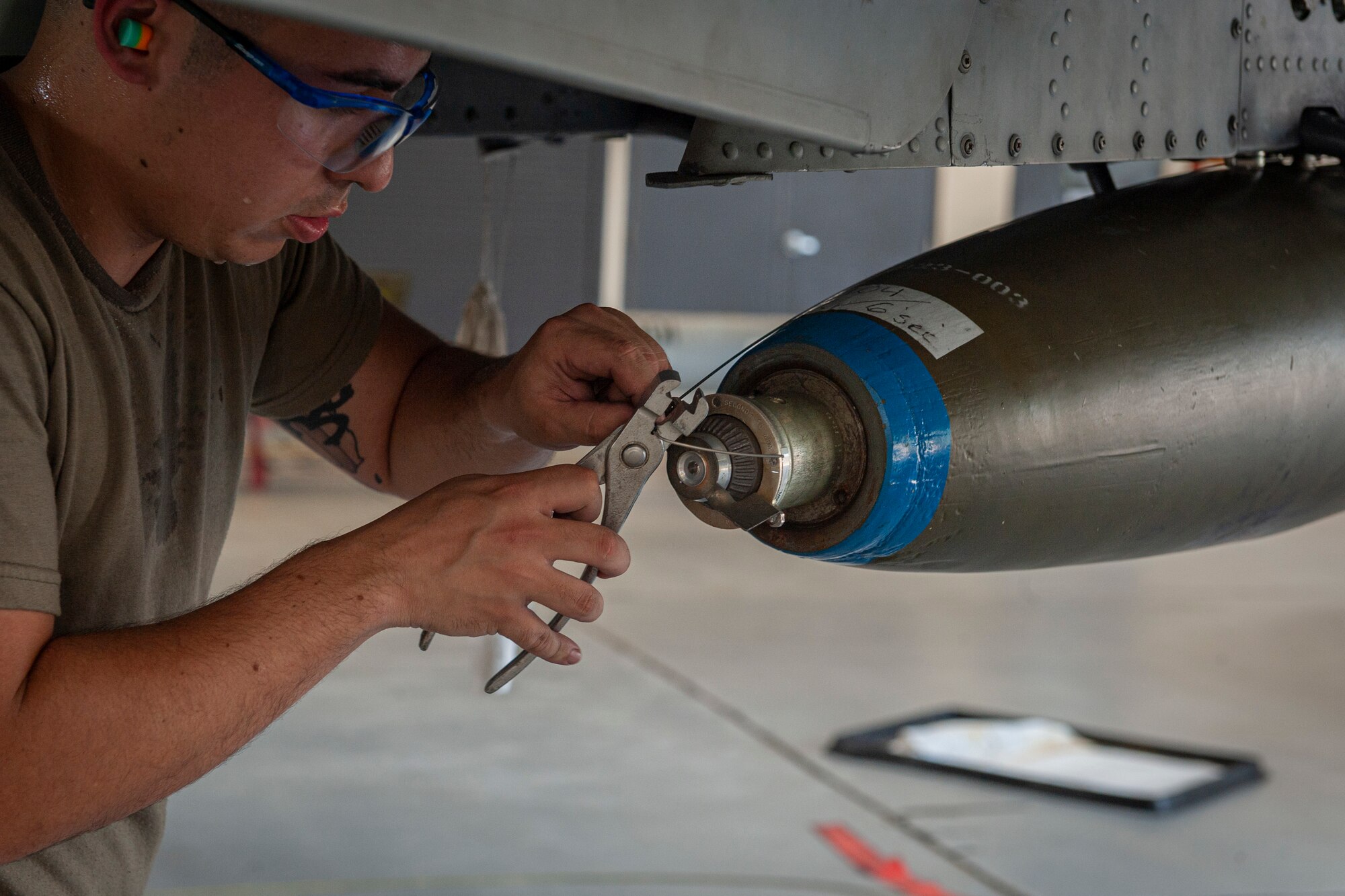 Photo of an Airman cutting a cord on a munition