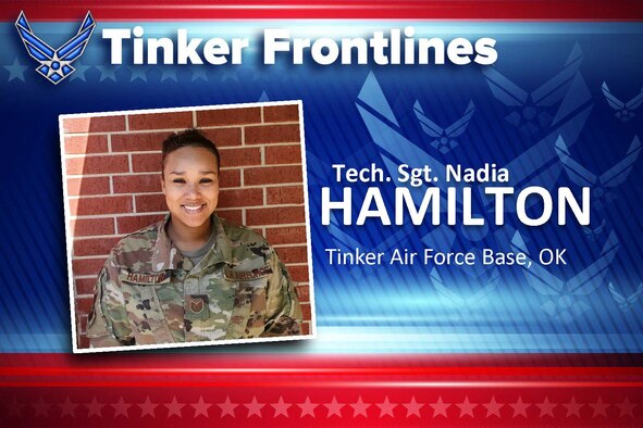 Female airman in uniform, standing in front of brick wall