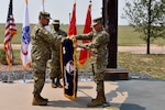 Gen. James H. Dickinson, U.S. Space Command commander, left, and Lt. Gen. Daniel L. Karbler, U.S. Army Space and Missile Defense Command commanding general, unfurl SMDC's colors to officially recognize the command as the Army Service Component Command to USSPACECOM during an. Aug. 21 ceremony at Schriever Air Force Base, Colorado.