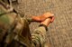 Over-the-shoulder view of an Airman with their hands together.