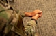 Over-the-shoulder view of an Airman with their hands together.