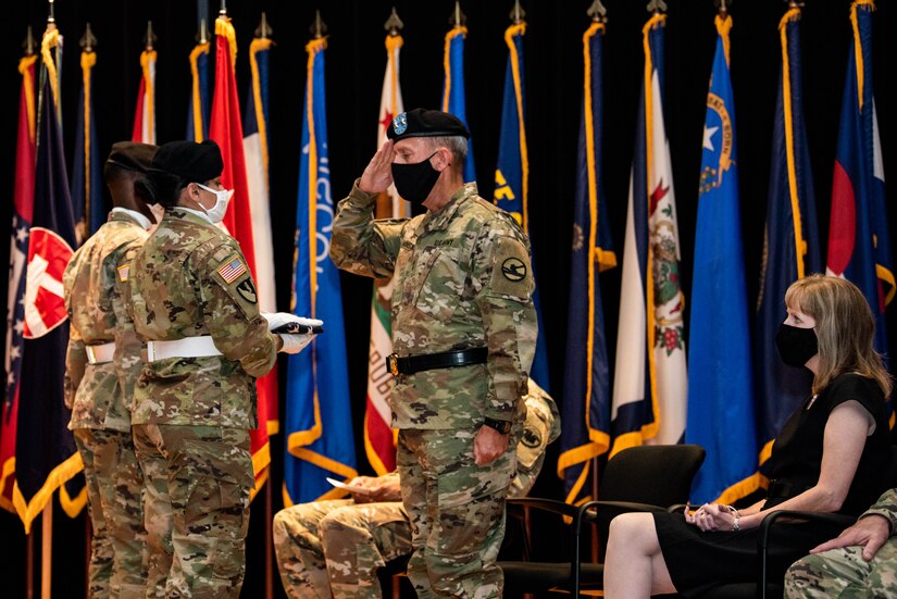 Maj. Gen. Steven W. Ainsworth, the outgoing commander of the 84th Training Command, receives the U.S. flag as his wife, Susanne, looks on during his relinquishment-of-command and retirement ceremonies, Aug. 22, 2020, at Fort Knox, Ky.