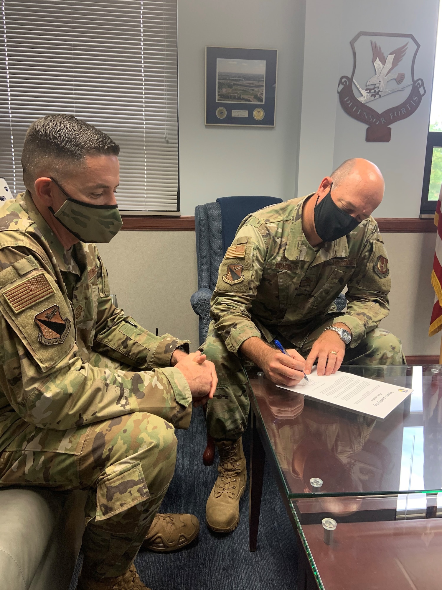 Chief Master Sgt. Jason Shaffer (left), 88th Air Base Wing command chief, looks on while Col. Patrick Miller, 88th Air Base Wing and installation commander, signs a proclamation for Women’s Equality Day on Aug. 26. This year’s theme for Women’s Equality Day is ‘Beyond the Scope of Women’s Suffrage: 100 Years of Progress,’ marking the 100th anniversary of the signing of the 19th Amendment affording women the right to vote. (U.S. Air Force photo/Stacey Geiger)