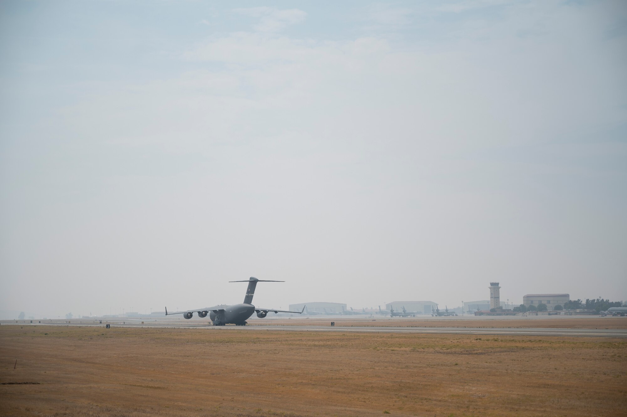 A C-17 Globemaster III assigned to the 21st Airlift Squadron, taxis on a runway at Travis Air Force Base, California.