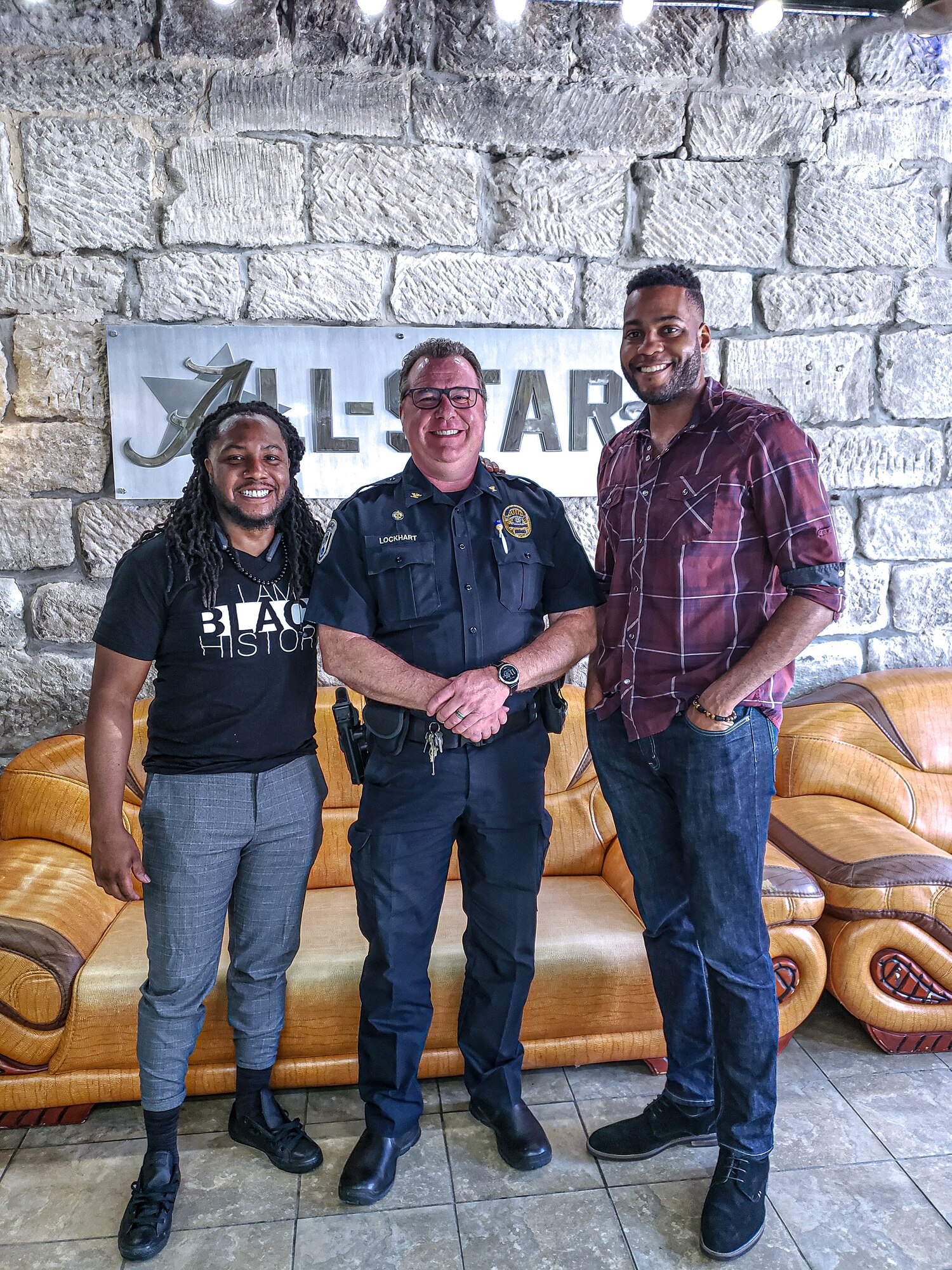 Will Taylor, left, a barbershop owner, Chief Rich Lockhart, center, the Warrensburg, Missouri, Chief of Police, and Staff Sgt. Jarrod Peterson, a 72nd Test and Evaluation Squadron software engineer, take a photo, at Warrensburg, Missouri. Taylor, Lockhart and Peterson worked together to come up with an idea to bring the community closer together. (Courtesy Photo)