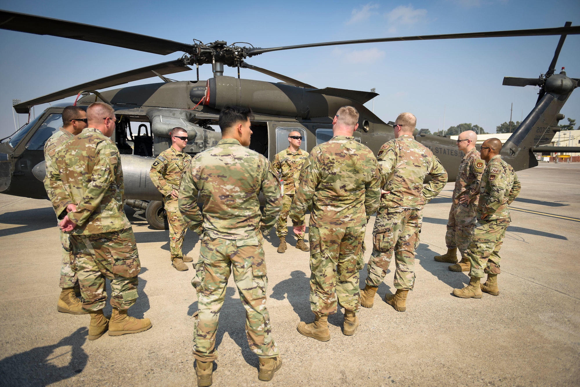 Airmen standing around a helicopter