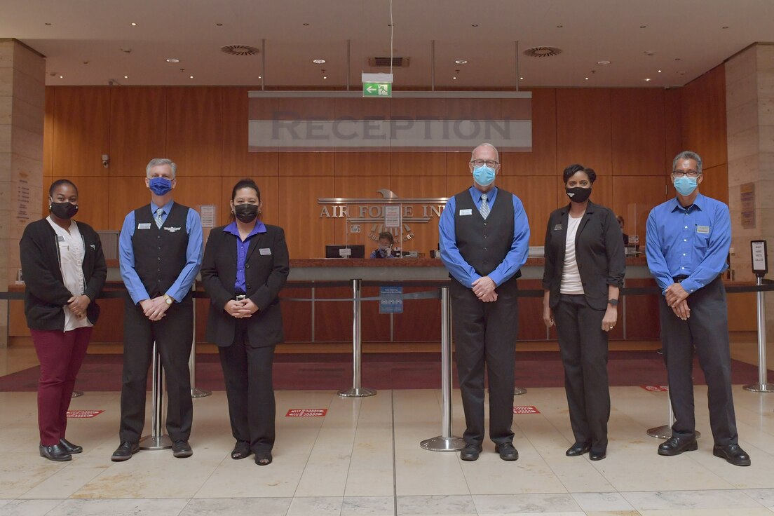 Hotel workers standing in a lobby.
