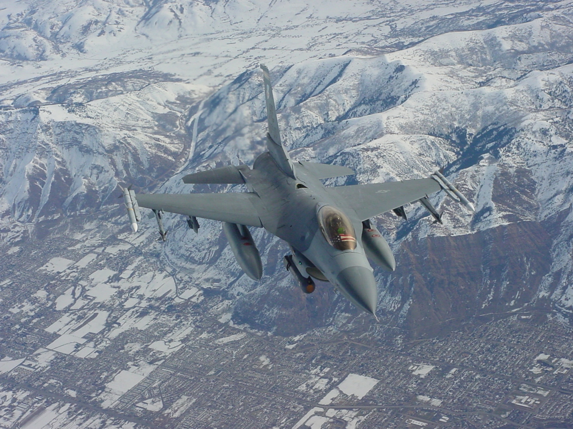 An F-16 flies over Salt Lake City as part of Operation Noble Eagle security for the 2002 Winter Olympic Games. The 388th Fighter Wing provided aerial security for all the XIX Olympics venues along the Wasatch Mountain Range in northern Utah.