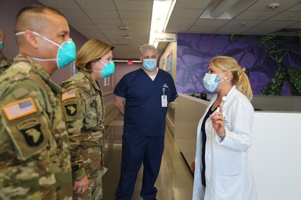 Military personnel speak with medical personnel in a hospital.