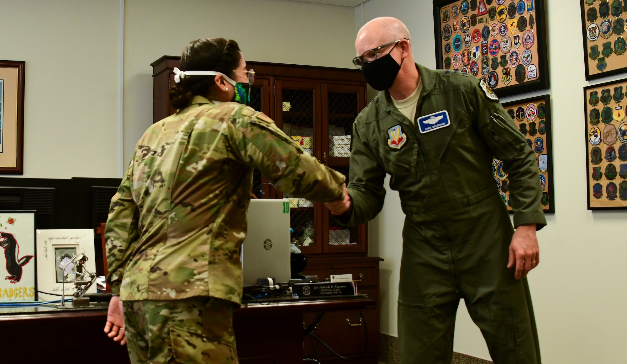 A photo of an officer receiving a coin from a general.
