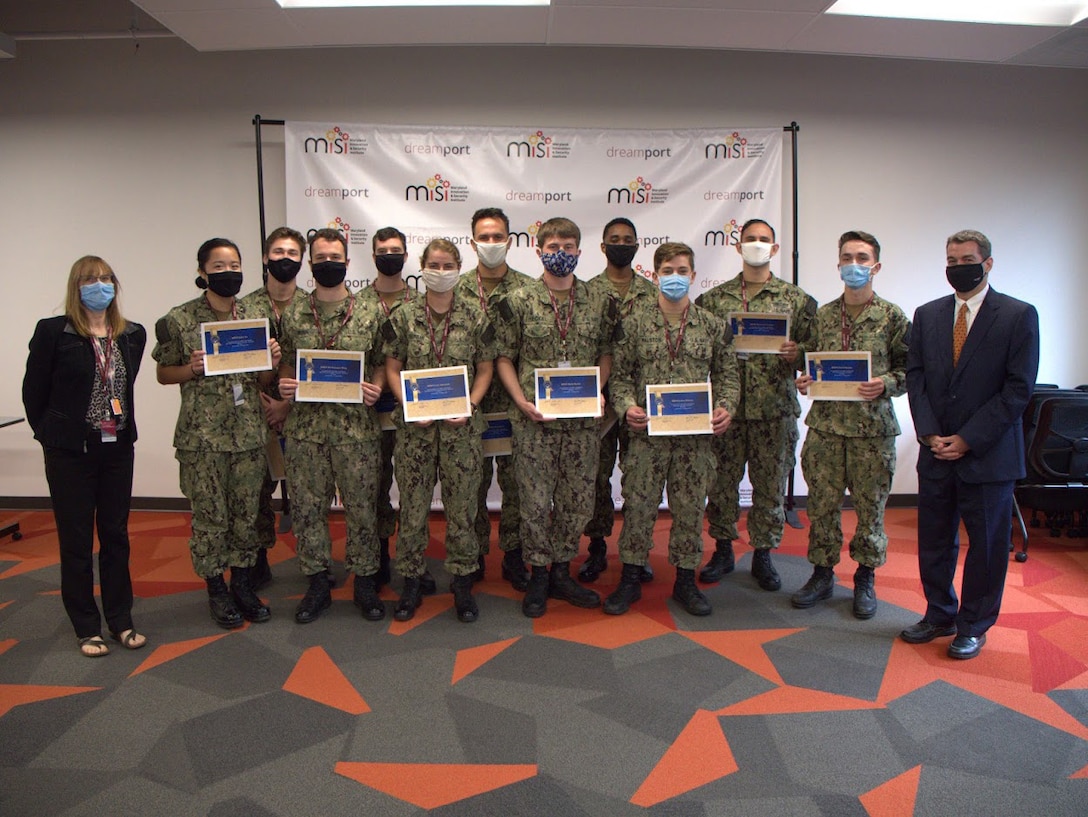 Midshipmen pose for a photo with David Luber, Executive Director, United States Cyber Command, at DreamPort in Columbia, Md., August 14.