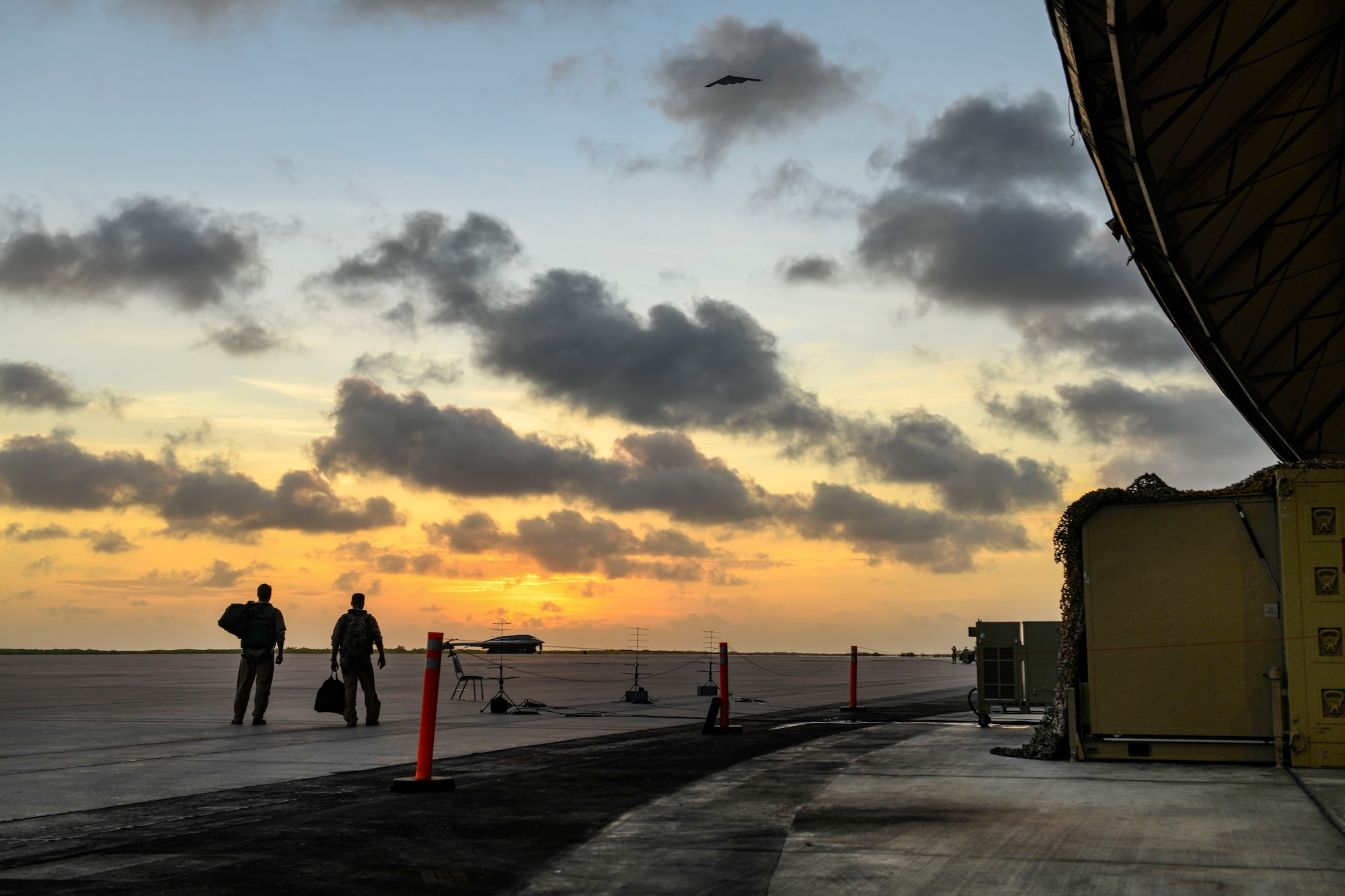 Two pilots assigned to the 393rd Expeditionary Bomb Squadron, Whiteman Air Force Base, Missouri, watch a B-2 Spirit Stealth Bomber fly over from U.S. Air Force Global Strike Command’s first mobile operations center during a deployment to Naval Support Facility Diego Garcia, August 24, 2020. Air Force Global Strike Command’s development of the mobile operations center is based on the National Defense Strategy’s objective to build lethality, strengthen alliances and streamline processes. Once implemented across AFGSC, the mobile operations center will allow commanders across the world to employ bomber forces to ensure a free and open Indo-Pacific and ability of AFGSC to deliver lethal, ready, long-range strike options anytime, anywhere. (U.S. Air Force photo by Tech. Sgt. Heather Salazar)