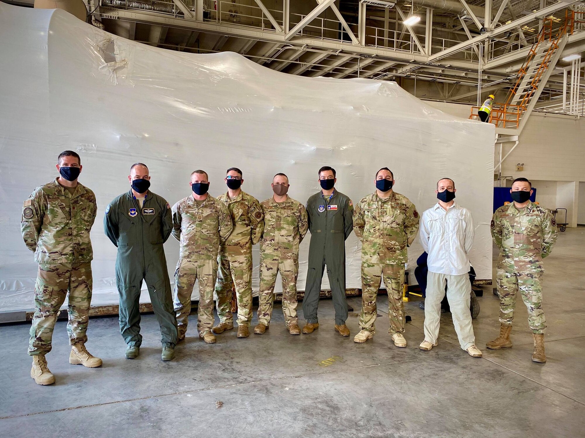Members of the 344th Training Squadron Career Enlisted Aviator Center of Excellence and 19th Air Force team pose for a photo in front of a newly positioned hypobaric altitude chamber at Joint Base San Antonio-Lackland, Texas, Aug. 25, 2020. The chamber was delivered from Tyndall Air Force Base and will support over 2,300 enlisted aircrew and several hundred permanent party officer and enlisted flyers from across the JBSA community.