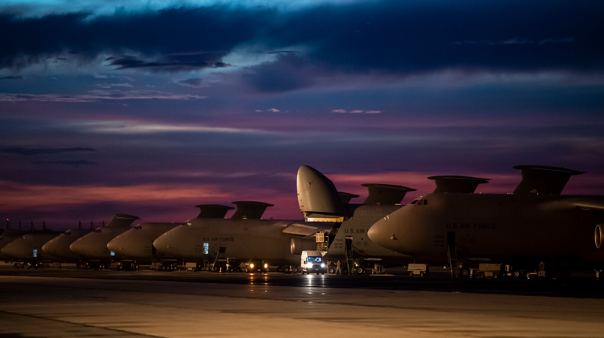 The sun sets over Dover Air Force Base, Delaware, as Airmen work on the flight line Aug. 12, 2020.  The 436th Airlift Wing generates global strategic airlift with both C-5M Super Galaxy and C-17A Globemaster III.  (U.S. Air Force photo by Senior Airman Christopher Quail)