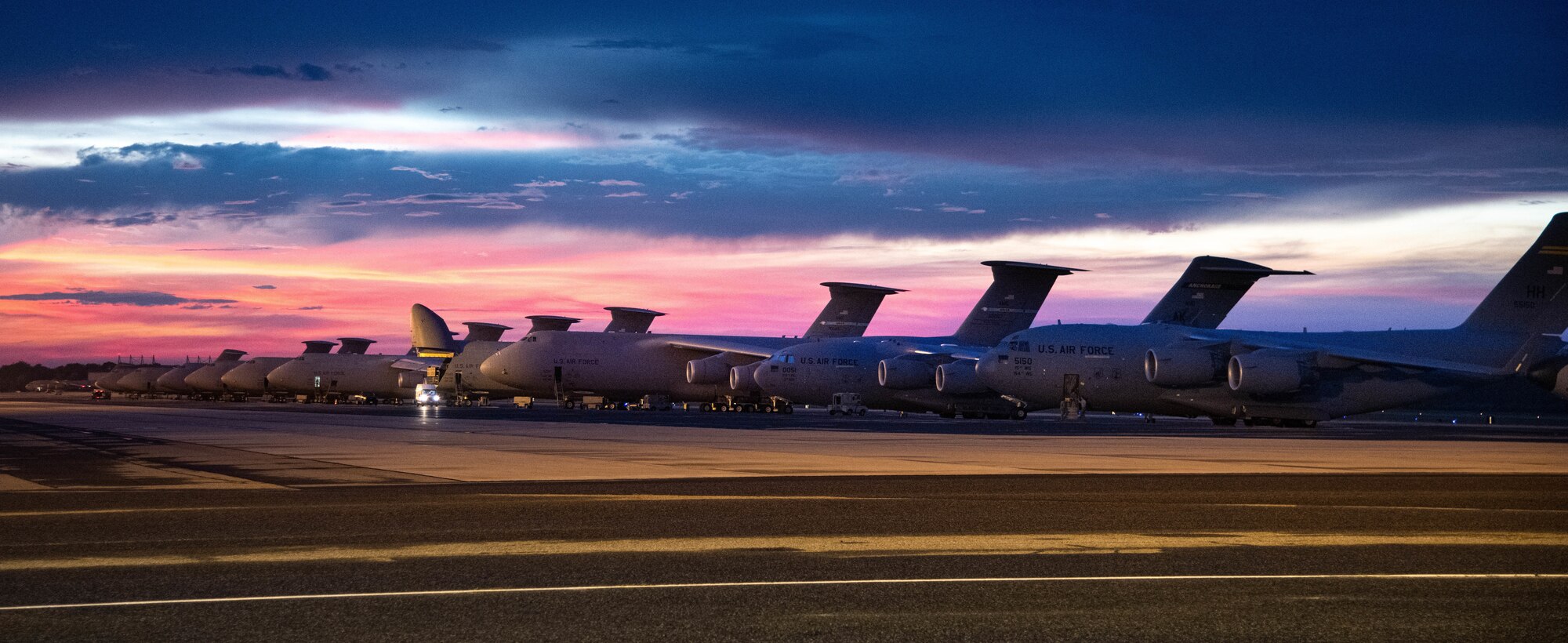 The sun sets over Dover Air Force Base, Delaware, as Airmen work on the flight line Aug. 12, 2020. The 436th Airlift Wing generates global strategic airlift with both C-5M Super Galaxy and C-17A Globemaster III. (U.S. Air Force photo by Airman 1st Class Faith Schaefer)