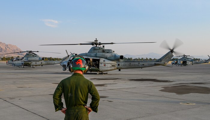 Marine watches as helicopter takes off on the flight line.