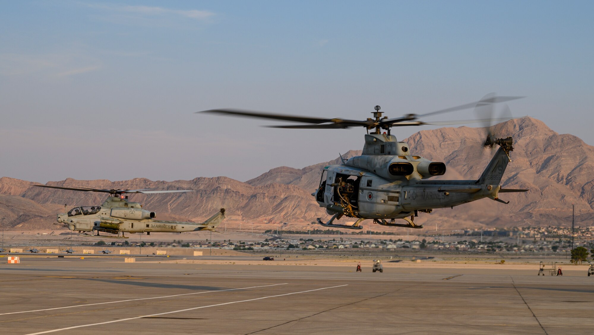 Helicopters take off from the flight line.