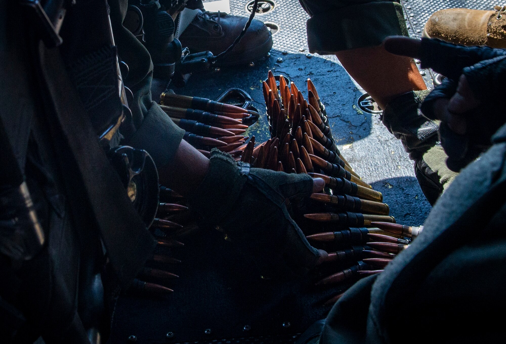 Marines grab ammunition in a helicopter.